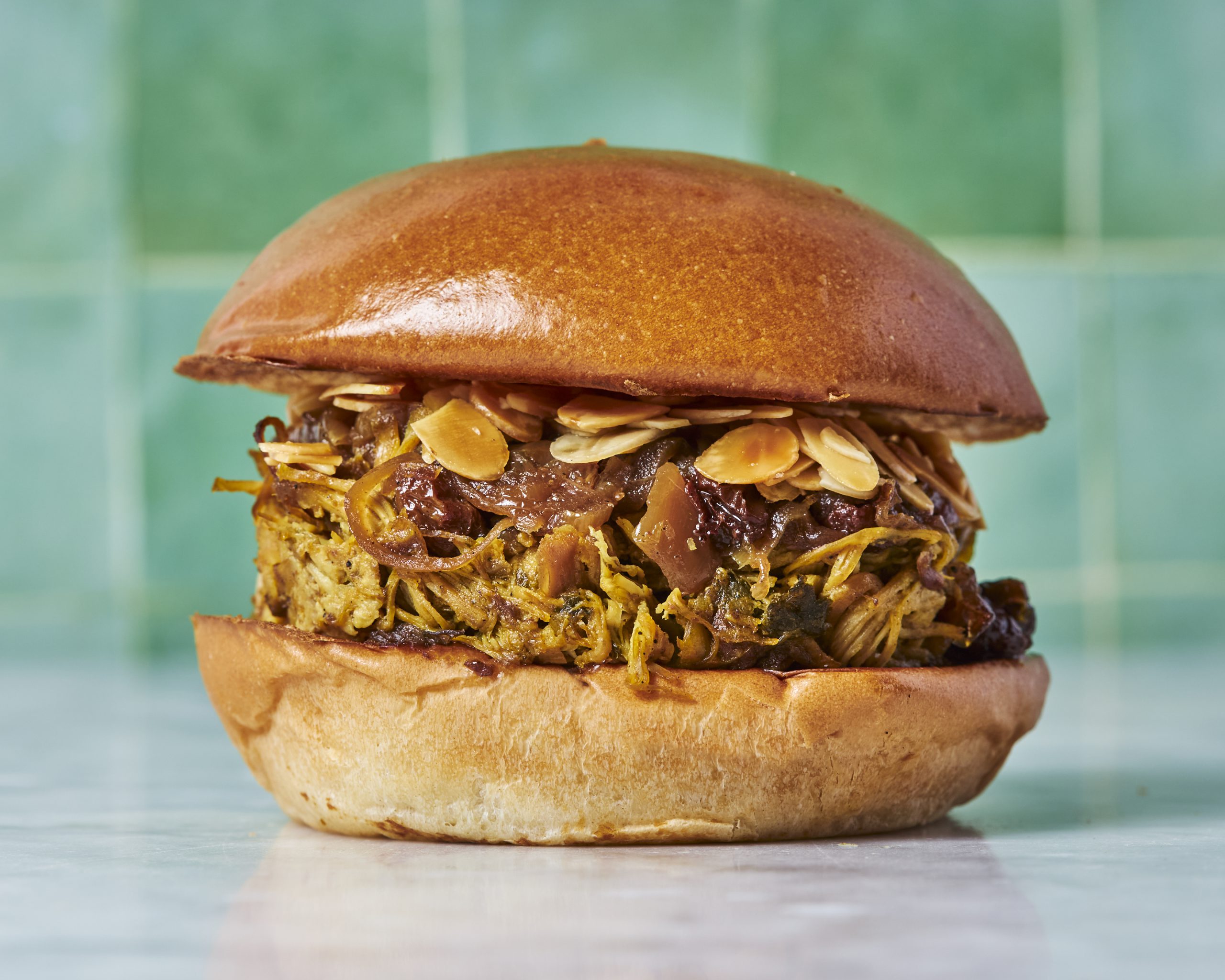 Effiloché de poulet, oignons et raisins secs caramélisés, amandes grillées.